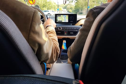 Two people in a modern car during a summer day.