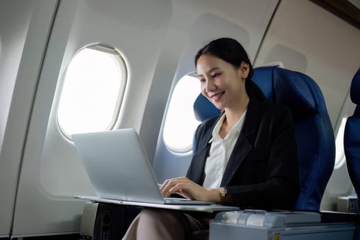 A young business woman travels to work outside the city by flying in business class. and work on airplanes with laptops.