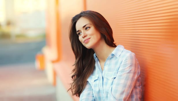 Portrait of beautiful happy smiling brunette young woman posing in the city