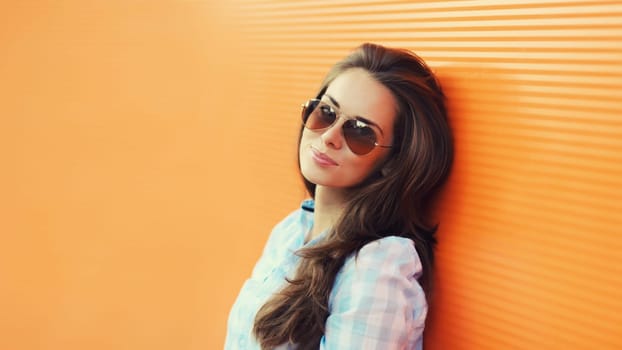 Portrait of beautiful brunette young woman in sunglasses posing in the city