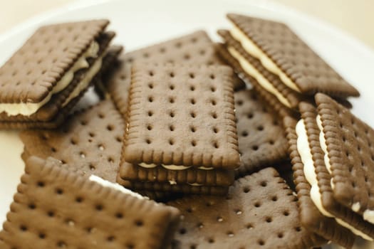 A plate filled with assorted crackers, neatly arranged on a wooden table.