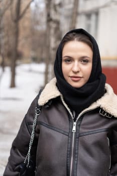 portrait of a young beautiful woman outside wearing a headscarf