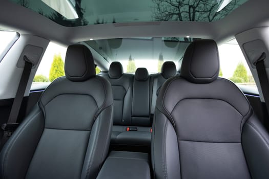 Luxury car leather seats. Interior of new modern clean expensive car. Passenger seats with leather. Closeup details. New car inside. Car cleaning theme. Panoramic glass sun roof