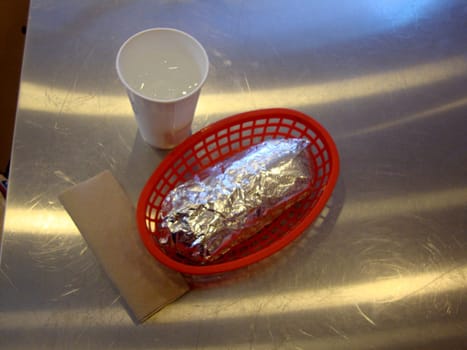 San Francisco - March 20, 2010: Tinfoil Wrapped Burrito in red plastic basket at Chipotle. With more than 2,000 locations, Chipotle had a net income of US$475.6 million and a staff of more than 45,000 employees in 2015.