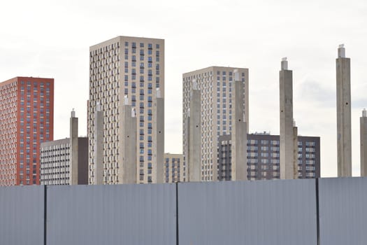 Concrete piles against background of new buildings