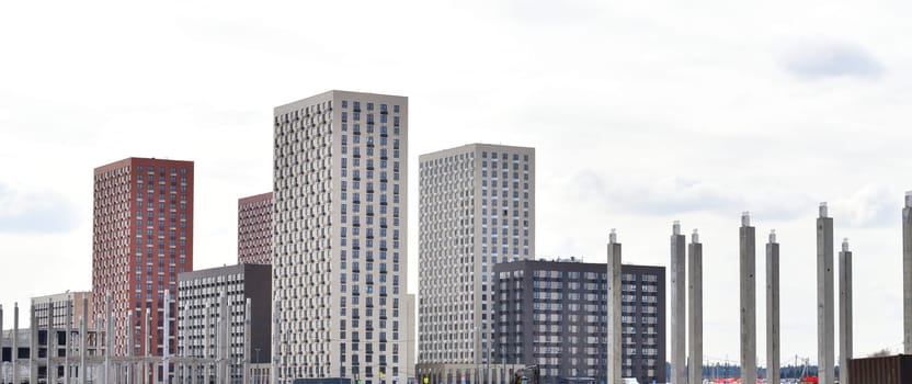 Concrete piles against background of new buildings