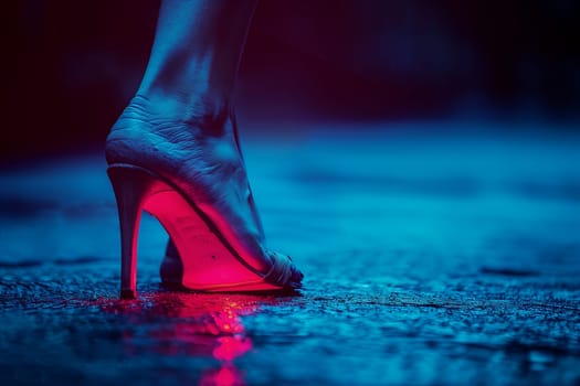 A single persons foot wearing a high heel stepping on a wet cobblestone street, illuminated by a red neon glow.