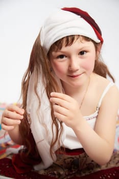 Portrait of Little girl in a stylized Tatar national costume on a white background in the studio. Photo shoot of funny young teenager who is not a professional model