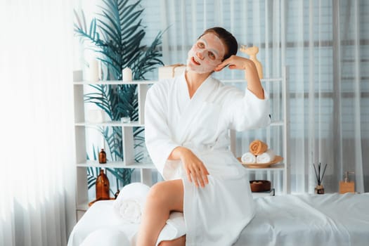 Serene modern daylight ambiance of spa salon, woman customer posing and indulges in rejuvenating with facial skincare mask. Facial skin treatment and beauty cosmetology procedure for face. Quiescent