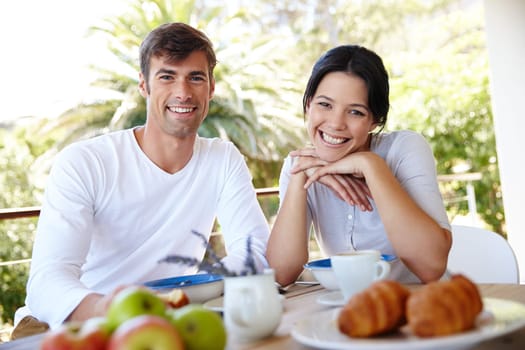 Couple, balcony and outdoor portrait for meal, love and affection in marriage or romance in nature. People, nutrition and smile at breakfast for healthy relationship, food and relax on vacation.