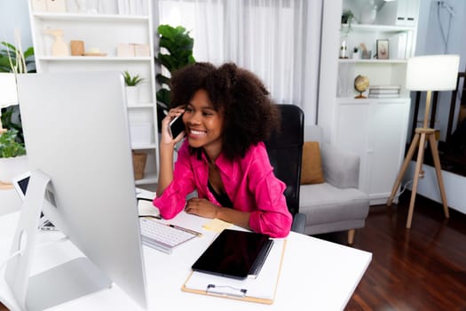 African woman talking with coworker or friend on the phone and looking at the screen with happy face. Achievement for promoting job position in the company with the good news life. Tastemaker.