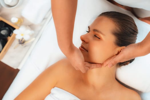 Panorama top view of woman enjoying relaxing anti-stress head massage and pampering facial beauty skin recreation leisure in dayspa modern light ambient at luxury resort or hotel spa salon. Quiescent