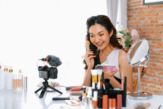 Woman influencer shoot live streaming vlog video review makeup uttermost social media or blog. Happy young girl with cosmetics studio lighting for marketing recording session broadcasting online.