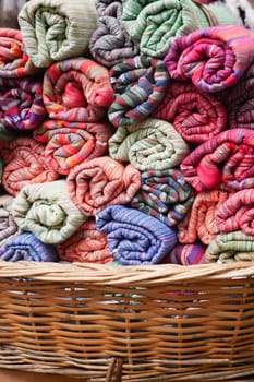 A storage basket made of wood filled with bath towels.