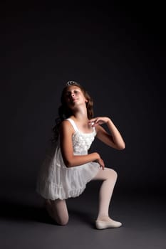 Image of smiling young ballerina posing on gray background