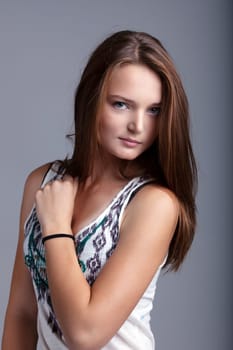 Image of attractive girl posing at camera, on gray backdrop