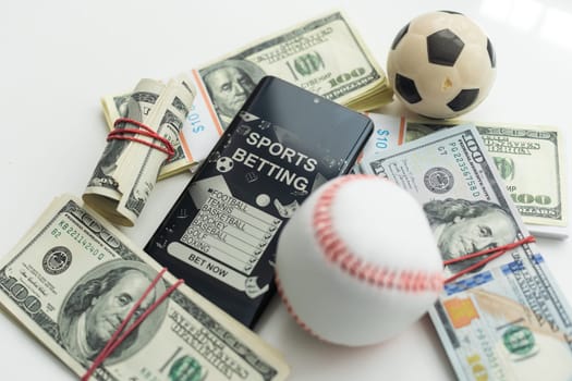 Smartphone with gambling mobile application and soccer ball with money close-up. Sport and betting concept. High quality photo