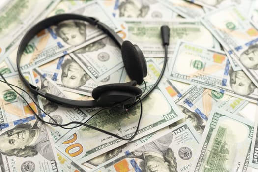 one hundred dollar bills and headphones. Close-up. High quality photo