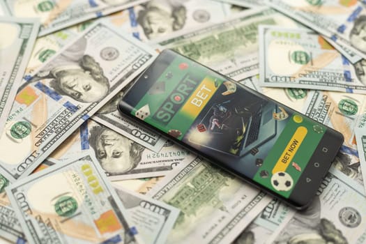 Smartphone with gambling mobile application with money close-up. Sport and betting concept. High quality photo