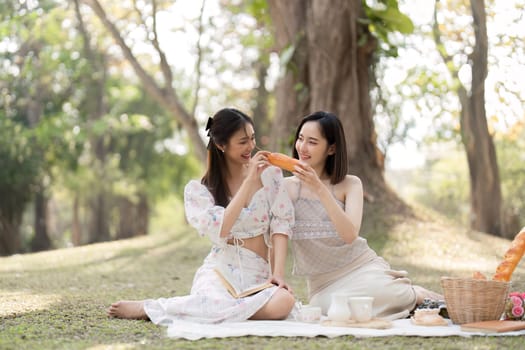 Two best friend do holiday activities, eat snacks, read books, and have picnics in the park to relax together..