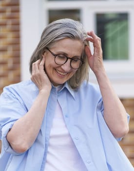 An older woman wearing glasses and a blue shirt.