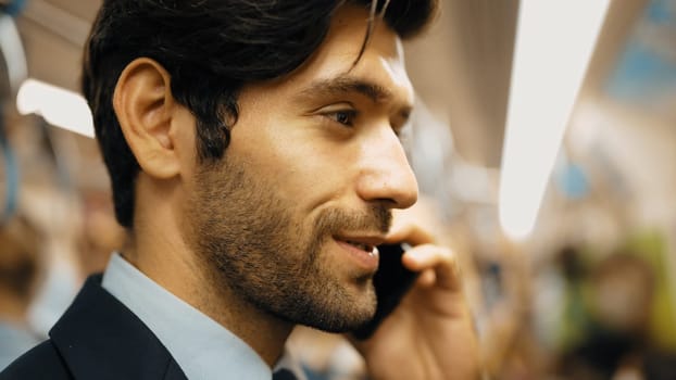 Closeup image of skilled business man face phone call to project manager in train with blurred background. Attractive caucasian investor talking to investor while standing at subway. Exultant.