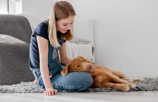 11-Year-Old Girl Plays With Nova Scotia Retriever Toller At Home On The Floor