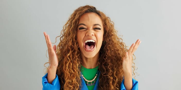 Excited woman, fist pump and celebration with deal, promotion or winning on a gray studio background. Portrait of happy female person or young winner with smile in surprise for bonus on mockup space.