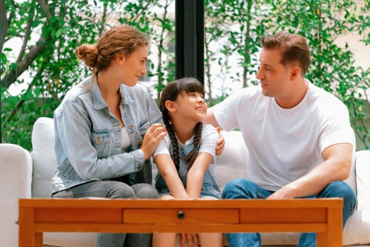 Parents comforting their daughter with loving hug, helping her feel secure and protected from fear, rest her head on shoulder. Happy family love and child care support concept. Synchronos