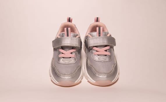 Baby sneakers. Baby shoes for spring or autumn on pink background. Fashion kids outfit