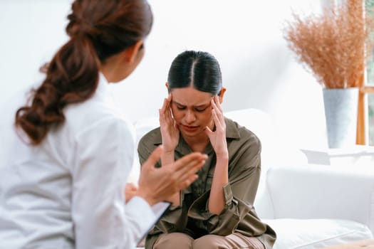 Sad PTSD woman patient in uttermost therapy for mental health with psychologist, depression or grief after life failure. Frustrated trauma young woman talking to a psychologist about emotion in clinic