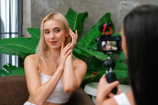 Two beautiful content creator making natural beauty and cosmetic tutorial on green plant leave garden video. Beauty blogger showing how to beauty care to social medial audience by selfie stick. Blithe