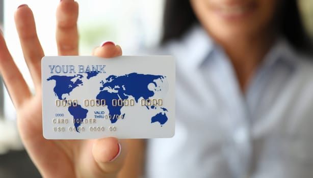 Woman arm holding banking card showing it to camera close-up