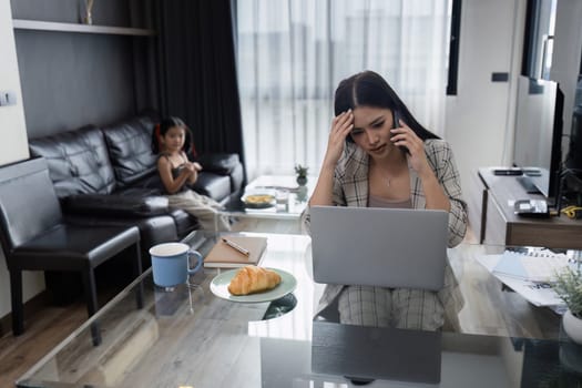 Businessman working at home. working woman talk on mobile and working on tablet and take care of her daughter during summer.