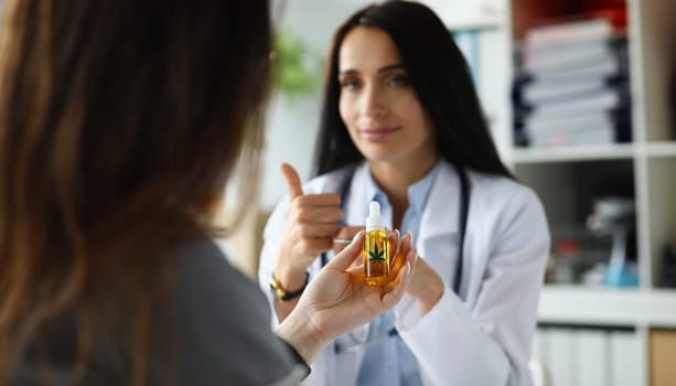 Visitor hand holding jar of cannabis concentrate oil closeup