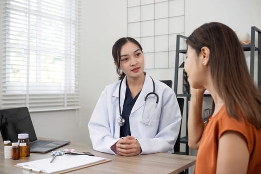 Female doctor and elderly female patient consulting about health problems in clinic.