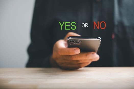 With smartphones businessman presents right and wrong icons for yes or no decision-making. Communication of choice and expertise. Think With Yes Or No Choice.