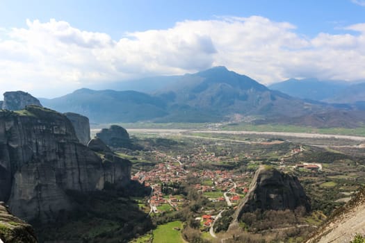 Immerse yourself in the panoramic beauty of Kalambaka, Greece, as seen from the timeless vantage point of the monasteries perched atop the towering cliffs of Meteora