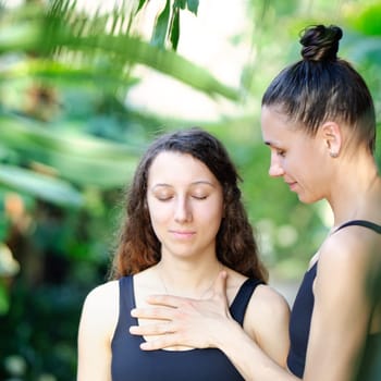 Yoga concept, meditation and sound therapy. Beautiful young girl at yoga session with her yoga and meditation teacher at tropical yoga retrear.