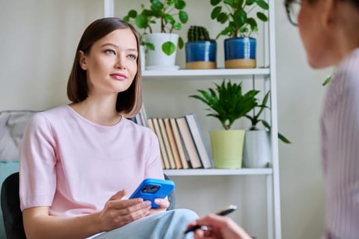 Young woman patient at meeting session with female psychologist therapist social worker counselor psychotherapist. Mental health professional help support treatment psychology psychotherapy counseling