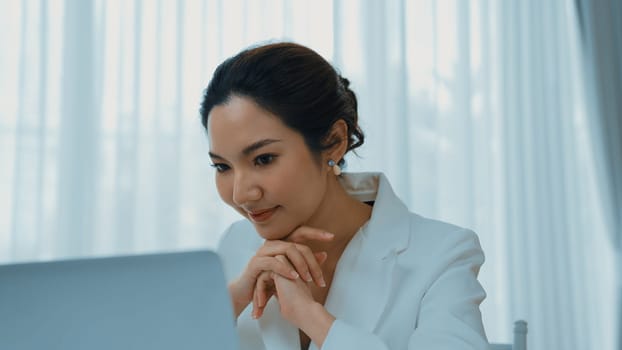 Young businesswoman sitting on the workspace desk using laptop computer for internet online content writing or secretary remote working from home. Vivancy