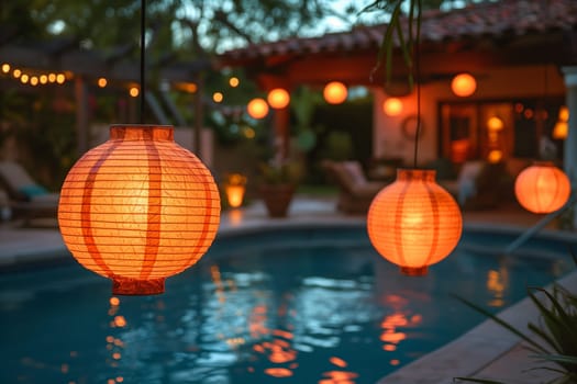 Lanterns hanging over the swimming pool cast a warm glow on the water as night falls.