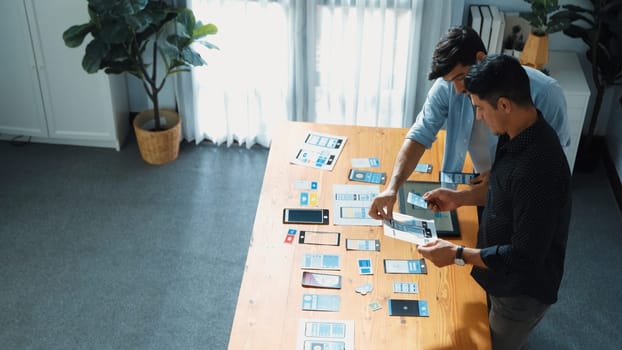 Top view of front-end developer design Ux Ui design for mobile phone interface with multicultural team. Professional smart designer walking and joining meeting while planning application. Convocation.