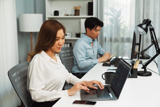 Beautiful IT developer analyzing coding program application beside coworker working on computer, analyzing intelligent database system development on business world market at modern office. Infobahn.