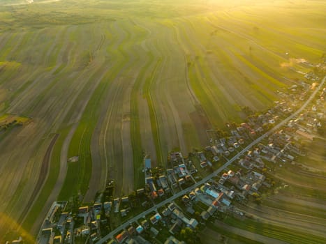 Top view of Suloszowa village and buildings in summer sun rays, farm green and yellow landscape of Krakow County, Poland