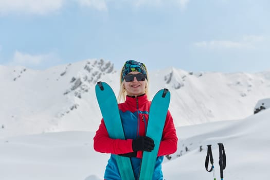 A professional woman skier rejoices after successfully climbing the snowy peaks of the Alps.