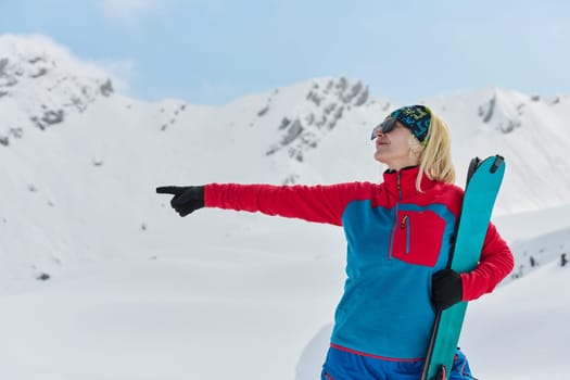 A professional woman skier rejoices after successfully climbing the snowy peaks of the Alps.