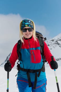 A professional woman skier rejoices after successfully climbing the snowy peaks of the Alps.