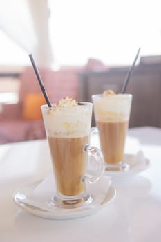 coffee is served in a tall glass glass with a straw. The concept of coffee drinks from the bar menu.