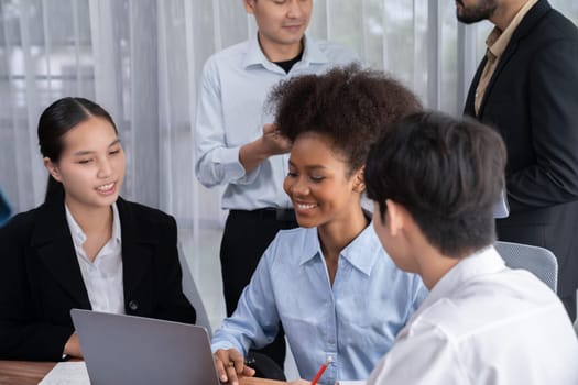 Happy diverse business people work together, discussing in corporate office. Professional and diversity teamwork discuss business plan on desk with laptop. Modern multicultural office worker. Concord